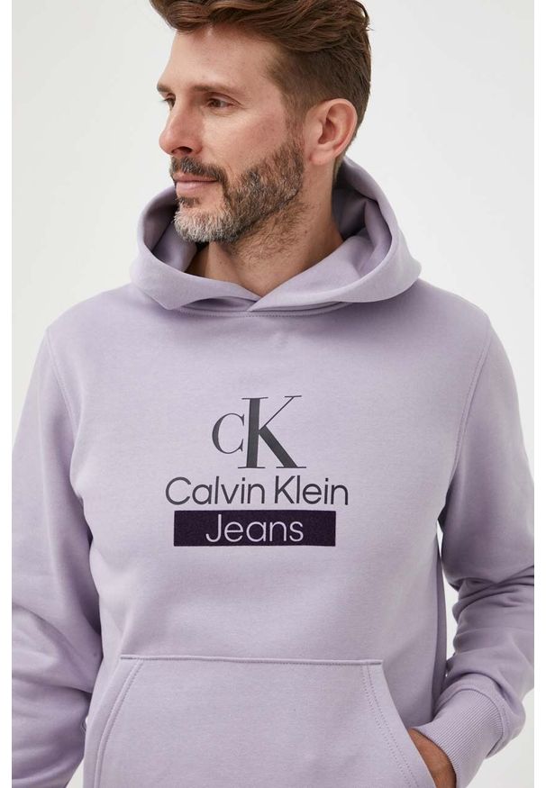 bluza-ck-meska-523yml-1.jpg Fioletowa bluza nierozpinana Calvin Klein Jeans z kapturem, z nadrukiem J30J323762 / 08720108053457 Bluzy męskie nierozpinane myBaze.com - obrazek 1